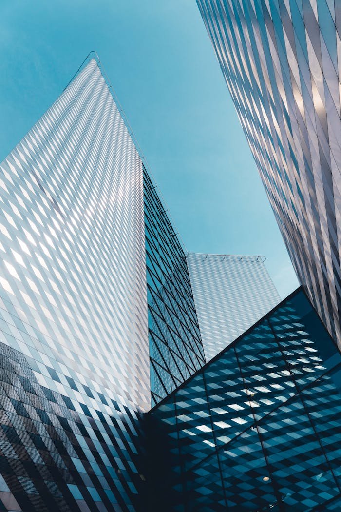 Futuristic skyscrapers in Vilnius with reflective geometric facades under a clear sky.
